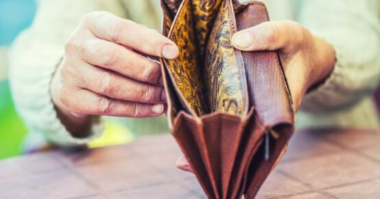 Pensioner woman holding hands wallet without money.