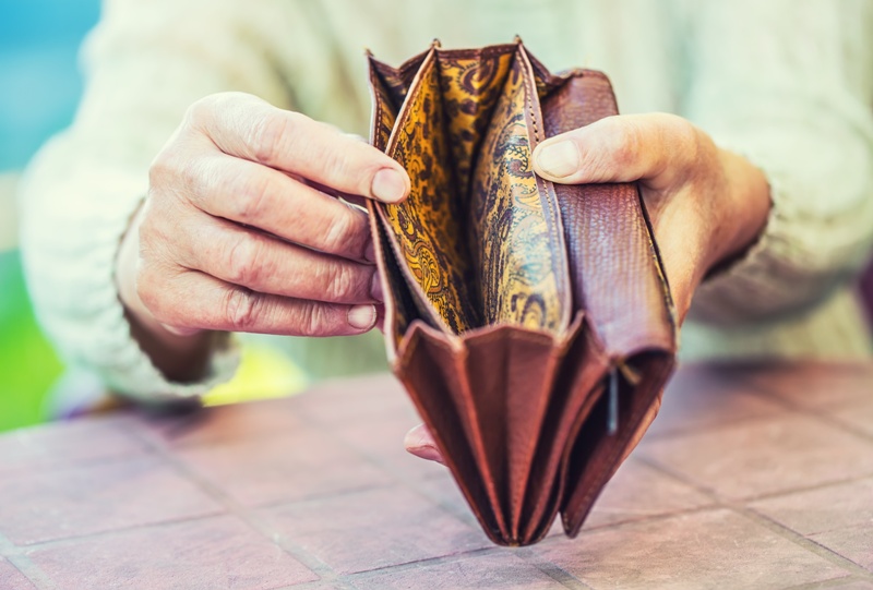 Pensioner woman holding hands wallet without money.