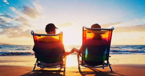 senior couple of old man and woman sitting on the beach watching sunset